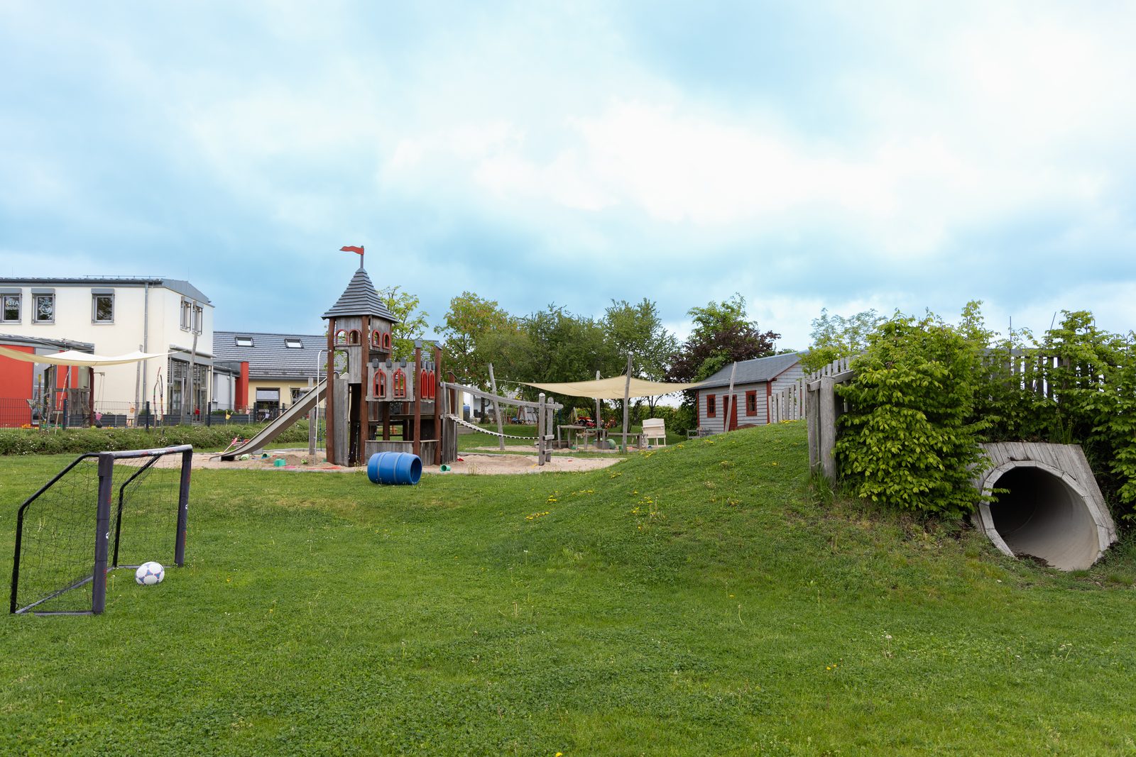 Wiese mit Fußballtor, Spielturm und Kriechtunnel